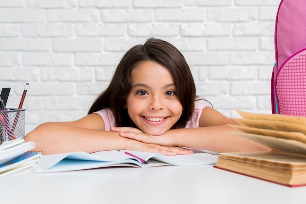 Hispanic cheerful girl sitting at desk