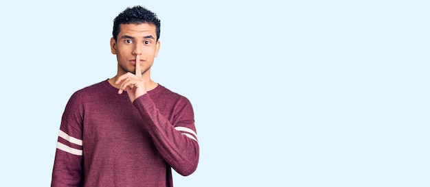 Free photo hispanic handsome young man wearing casual clothes asking to be quiet with finger on lips silence and secret concept