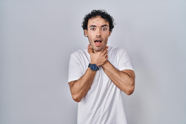 Free photo hispanic man standing over isolated background shouting suffocate because painful strangle. health problem. asphyxiate and suicide concept.