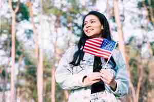 Free photo hispanic teenage girl holding american flag on stick