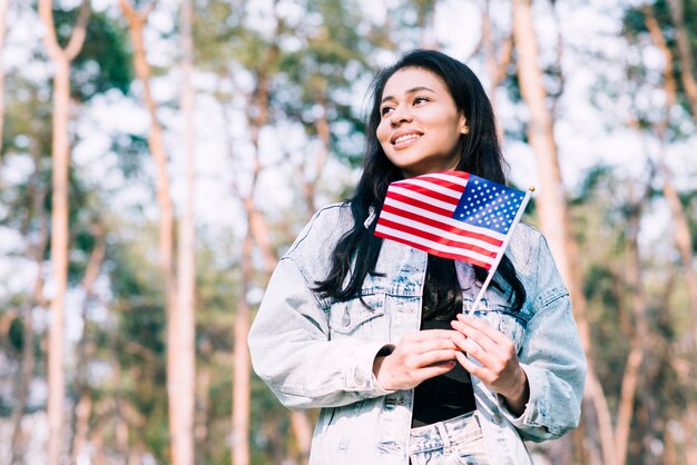 Hispanic teenage girl holding American flag on stick