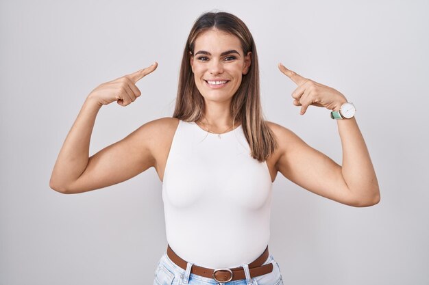 Hispanic young woman standing over white background smiling pointing to head with both hands finger, great idea or thought, good memory