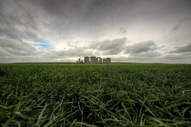 Free photo historic ancient building in the middle of a beautiful green field under the gloomy sky