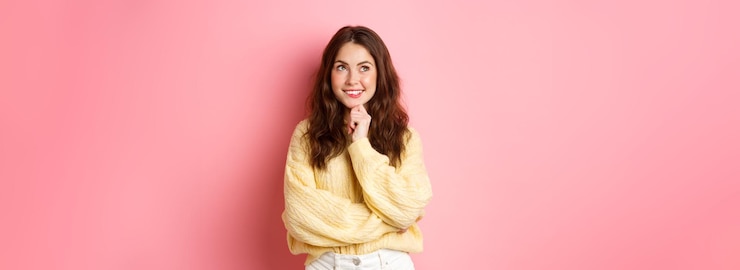 Free Photo hmm very interesting thoughtful young beauty girl looking aside at logo reading promotional text and thinking smiling pleased pink background