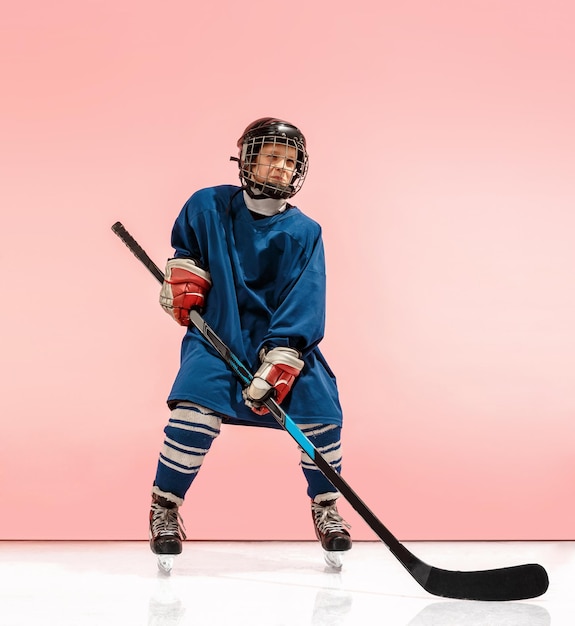 A hockey player with equipment over a pink