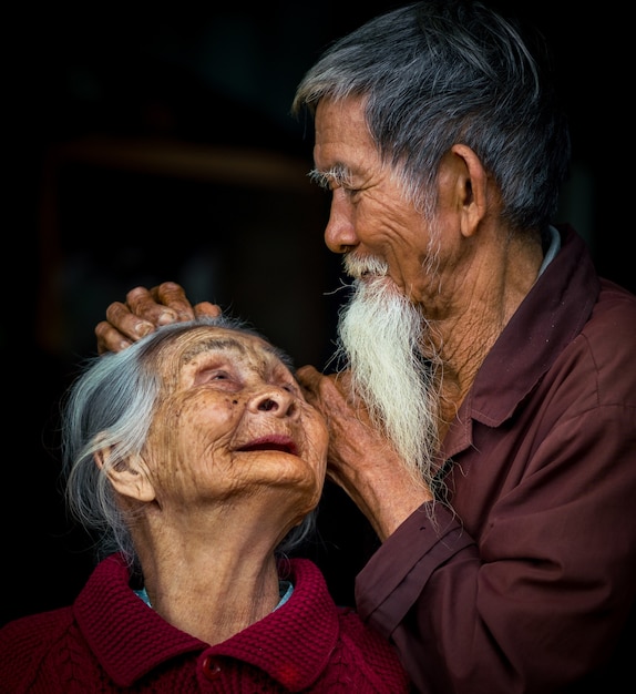 HOI AN, VIETNAM - Mar 14, 2018: A detailed close up portrait of an Asian couple with a black background