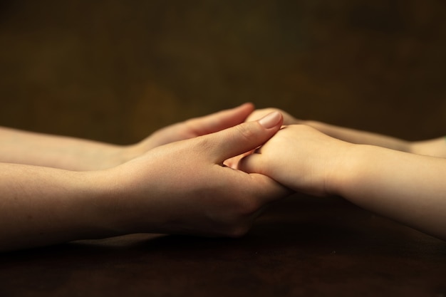 Holding hands, clapping like friends. Close up shot of female and kid's hands doing different things together. Family, home, education, childhood, charity concept. Mother and son or daughter, wealth.