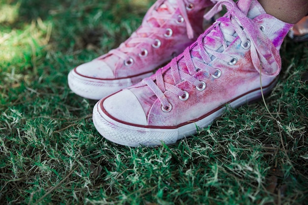 Free photo holi color over the white canvas shoes on green grass