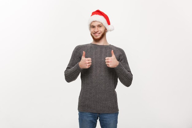 Holiday Concept Young beard man in sweater giving thumb up to camera