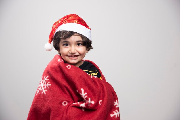 Holiday time with kid disguised in red Santa Claus uniform