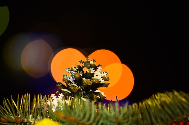 크리스마스 장식용 화려한 원뿔과 디포커스 보케가 있는 전나무 가지와 화려한 배경, 복사 공간