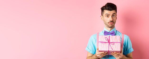 Holidays and celebration concept attractive young man with moustache wearing festive outfit with bow