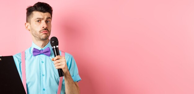 Free photo holidays concept funny man with bowtie making speech perform on party events holding script on clipb