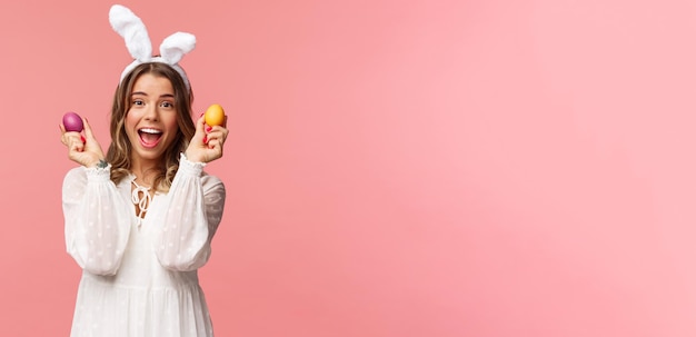 Free photo holidays spring and party concept portrait of excited charming young woman celebrating easter in rab