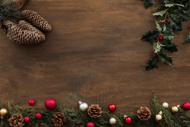 Holly branches with cones on table 