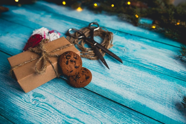 Foto gratuita decorazione del regalo di natale di agrifoglio su fondo di legno blu