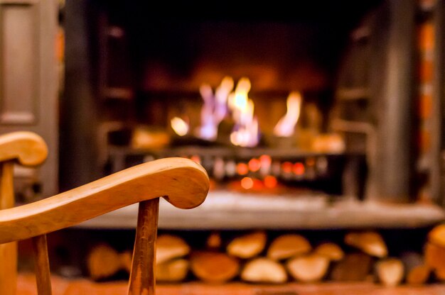 Home comfort. Rocking chair near the fireplace. Photo of interior of room. Rocking chair in the living room with decorated modern fireplace