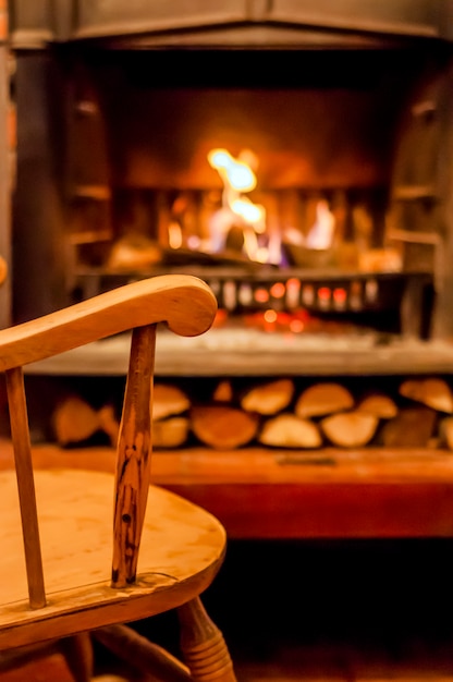 Home comfort. Rocking chair near the fireplace. Photo of interior of room. Rocking chair in the living room with decorated modern fireplace