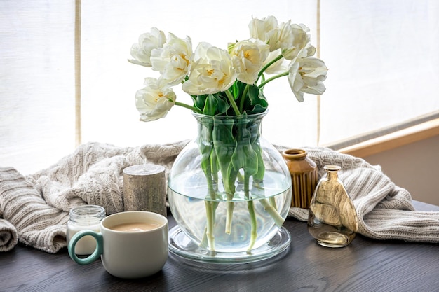 ガラスの花瓶とキャンドルのチューリップの花束と家の構成