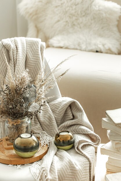 Home cozy interior of the room with books and dried flowers in a vase.