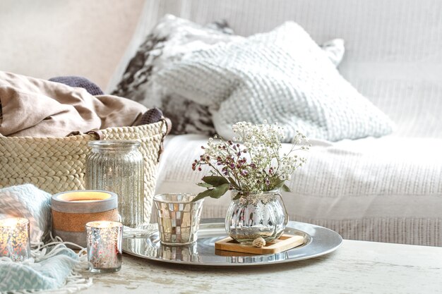 Home decorations in the interior. A turquoise blanket and wicker basket with a vase of flowers and candles