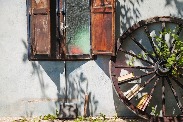 Home exterior with plants and old wheel