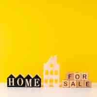 無料写真 黄色の背景にレタリングの販売のための家