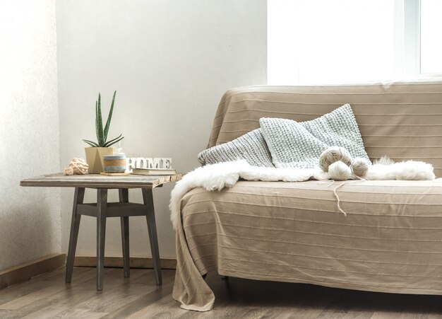 Home sofa with objects of cozy decor in the living room