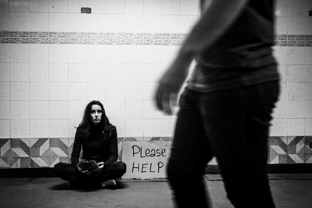 でお金の寄付を求めているホームレスの乞食の女性は署名を助けてください