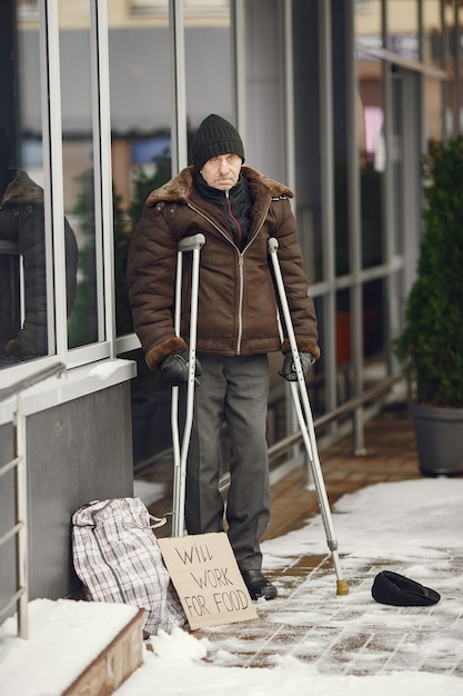 Homeless standing near building.