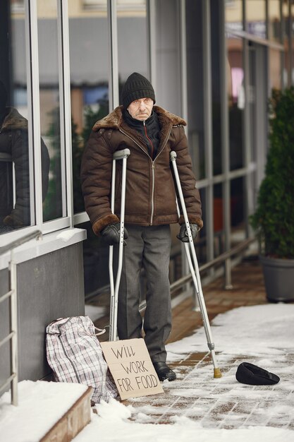 Homeless standing near building.