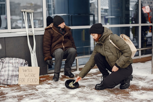 Homeless in a winter city. Man asking for food.