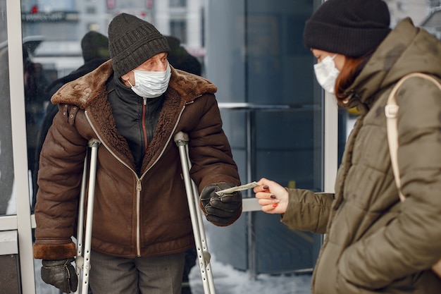 冬の街でホームレス。食べ物を求める男。