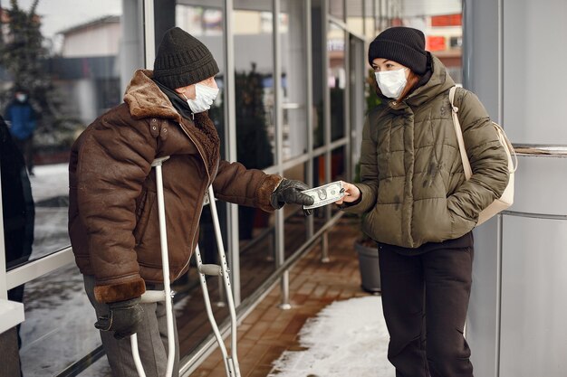 冬の街でホームレス。食べ物を求める男。