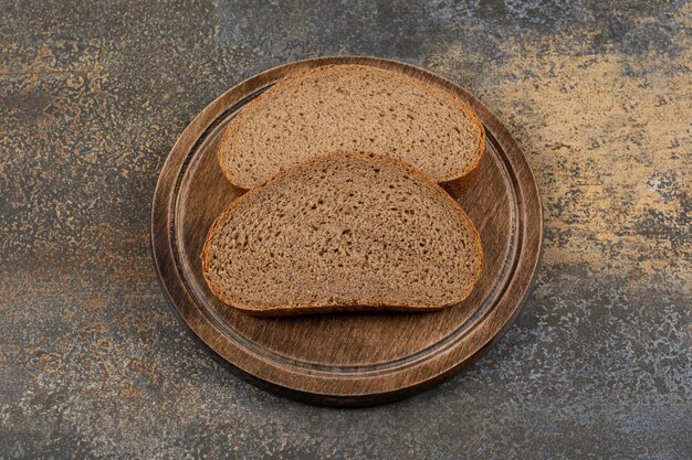 Homemade black bread on wooden board.