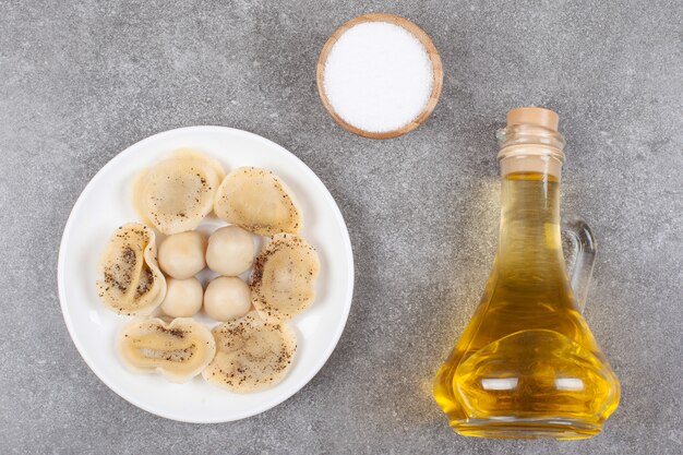 Homemade boiled dumplings on white plate with oil