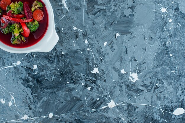 Homemade borsch soup in a bowl, on the blue background. 