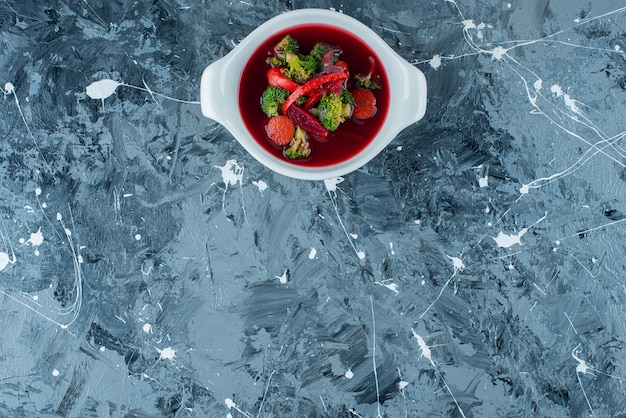 Homemade borsch soup in a bowl, on the blue background. 