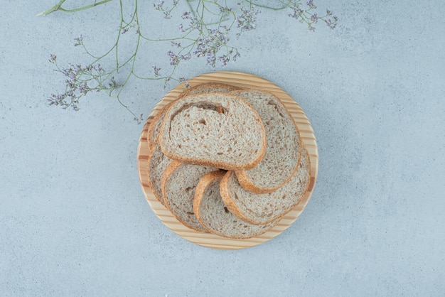 Homemade bread slices on wooden plate