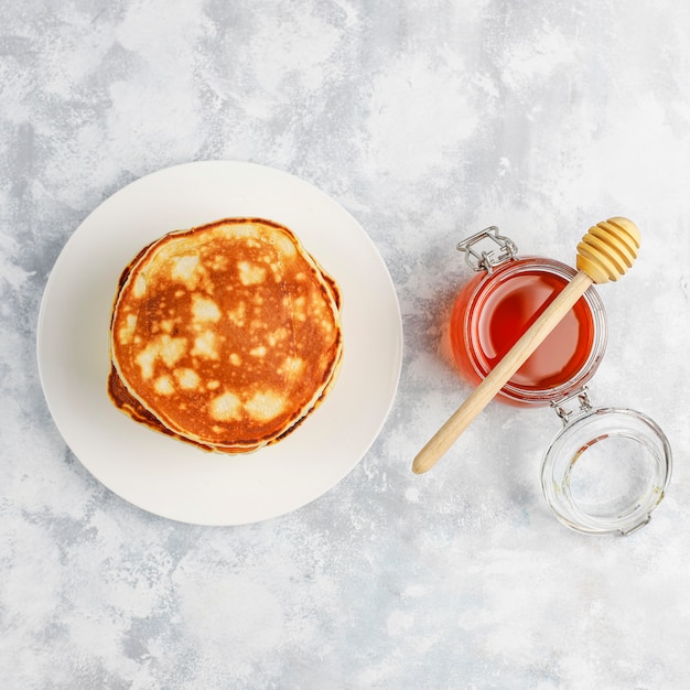 Homemade breakfast: american style pancakes served with pears and honey with a cup of tea on concrete . Top view and copy 