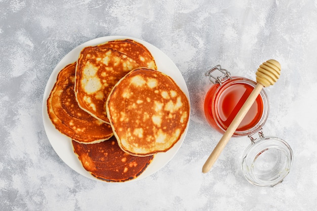 Homemade breakfast: american style pancakes served with pears and honey with a cup of tea on concrete . Top view and copy 