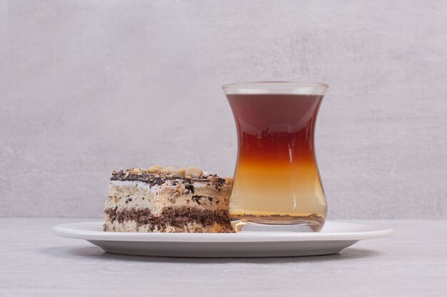 Homemade cake and cup of tea on white plate.