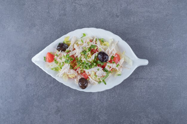 Homemade chicken salad on leaf-shaped plate.