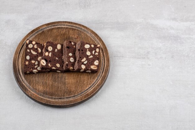 大理石のテーブルの上に、木の板の上に自家製チョコレートブラウニー。