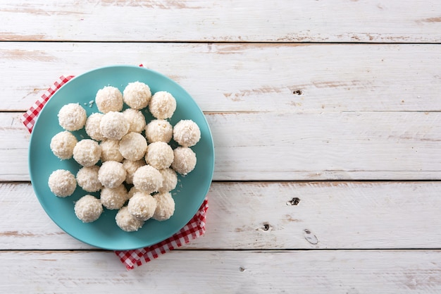 Free photo homemade coconut balls on white wooden table