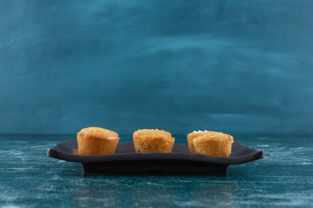 Homemade cookies on a black plate, on the blue background. High quality photo