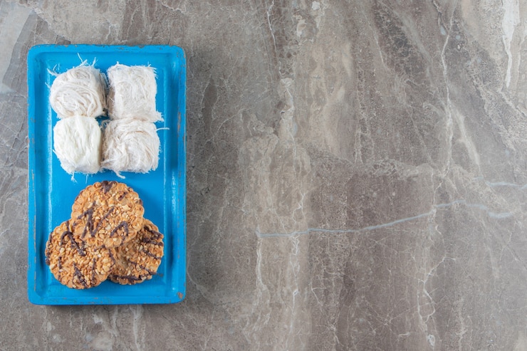 मुफ़्त फोटो homemade cookies and turkish cotton candy on a wooden plate on blue.