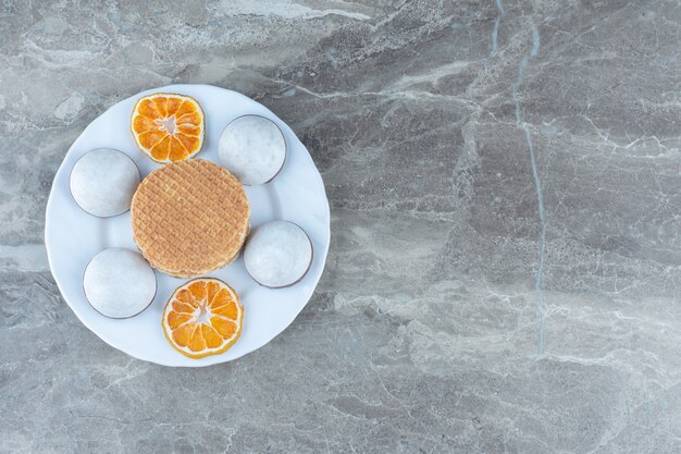 Homemade cookies and waffle with dry orange slices.