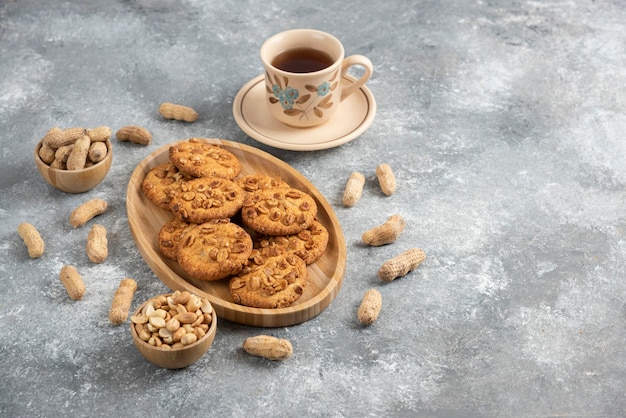 お茶と木の板に有機ピーナッツと蜂蜜と自家製クッキー。