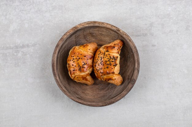 Homemade croissants on a board, on the marble table. 